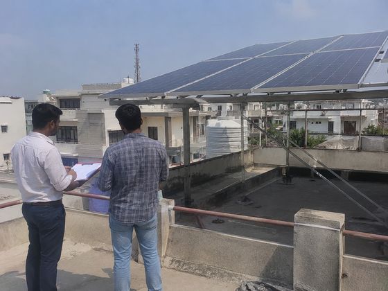Site assessment beside a completed rooftop solar structure