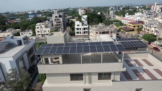 Aerial view of a large rooftop solar array over a terrace