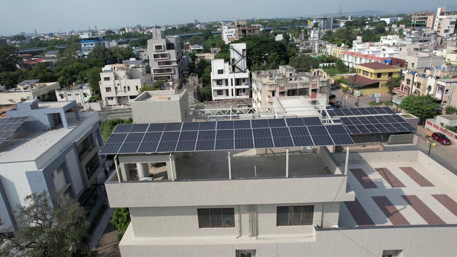 Aerial view of a large rooftop solar installation over a building terrace